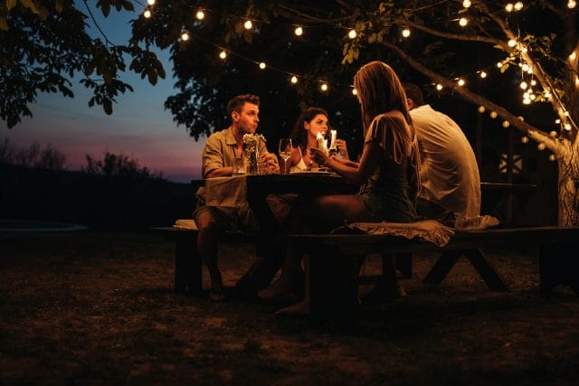 Two couples having a romantic dinner outdoors