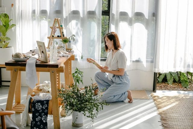 Una joven disfrutando de decorar su hogar con elementos naturales y plantas